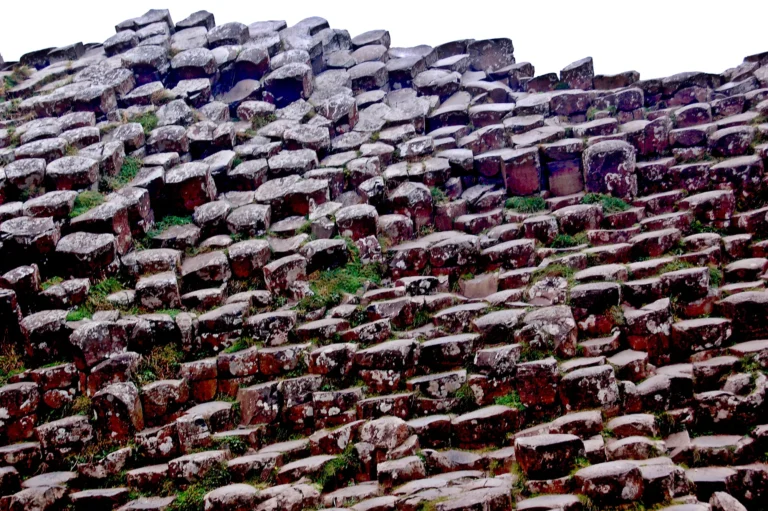 Natural basalt columns on a coastline, showing the dense dark stone